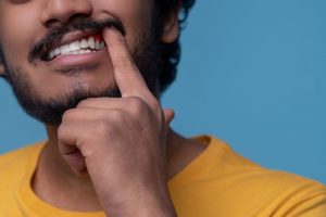 person experiencing bleeding gums while brushing teeth